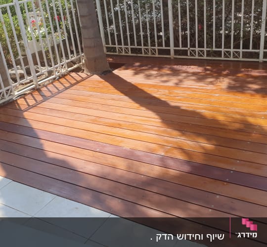 דק עץ עם צללים וגדר מתכת לבנה